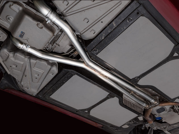 AWE Tuning 05-07 Chevrolet Corvette C6 6.0L X-Pipe, stainless steel exhaust component with polished finish, installed on vehicle.
