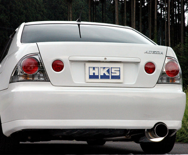 HKS SILENT Hi-Power SXE10 3S-GE catback exhaust system installed on a Toyota SXE10 3S-GE engine, showcasing the polished muffler and piping.