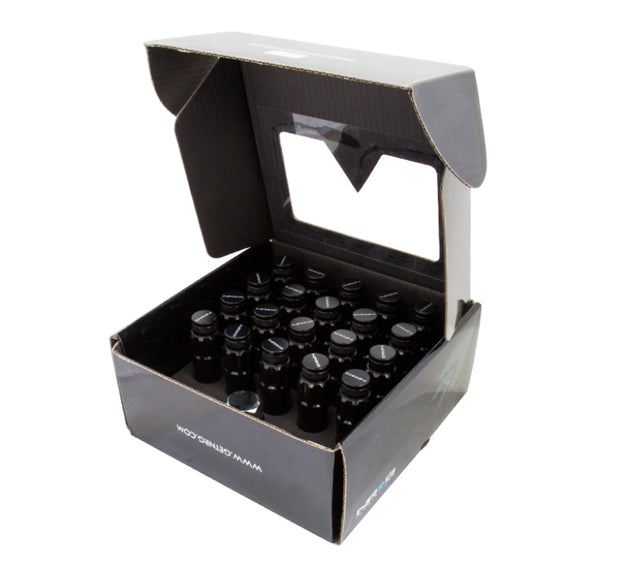 NRG 700 Series M12 x 1.5 steel lug nuts with dust cap cover set, locks, and lock socket in black, shown on a vehicle wheel.
