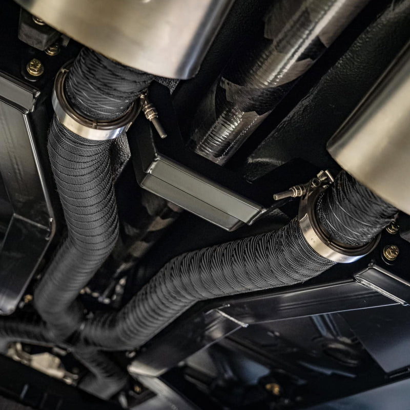 DEI Exhaust Wrap Kit in black titanium with locking ties and tie tool, showing the wrapped exhaust heat shield and securing tools.