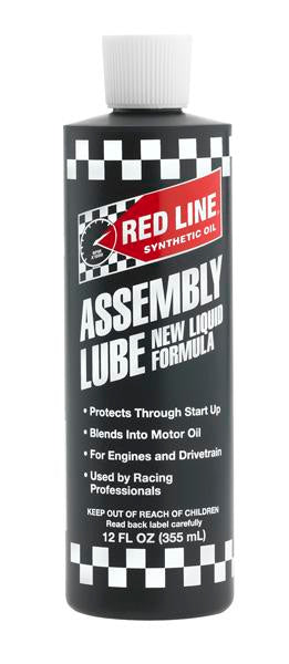 Red Line Liquid Assembly Lube in a 12oz bottle, featuring red and white packaging, used for engine assembly and lubrication.