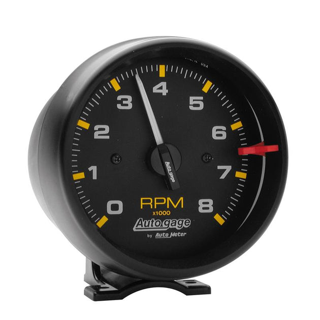 AutoMeter Autogage black 8,000 RPM pedestal mount tachometer gauge showing RPM dial and mounting hardware.