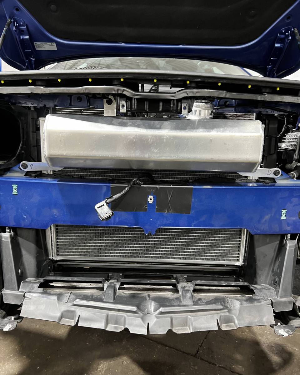 LMP Cadillac CT5-V Blackwing expansion tank showing black plastic construction with mounting fittings and fluid connections.