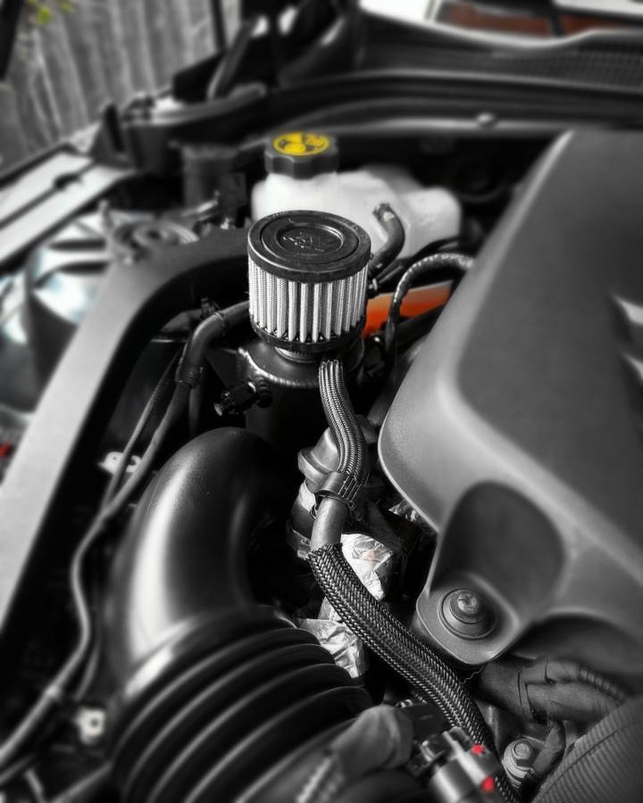 LMP Cadillac CT4-V Blackwing catch can, black metal engine part with hoses attached, designed for vehicle performance.