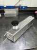 LMP Cadillac CT4-V Blackwing expansion tank in black, showing the tank with mounting and hose connections visible.