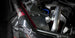 HKS Racing SQV universal blow off valve installed on a turbocharged engine, showcasing its sleek black design and metal components.