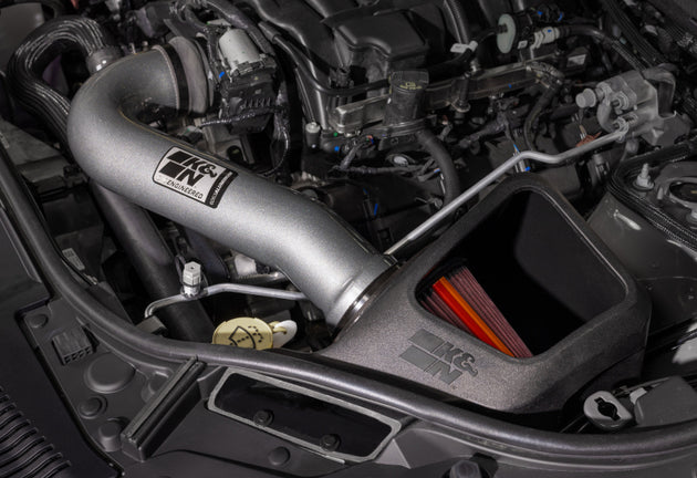 K&N Engineering aluminum cold air intake for 2011-2021 Jeep Grand Cherokee NextGen, showing the sleek metal intake tube and filter connection
