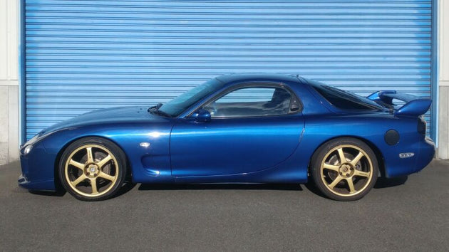 HKS HIPERMAX S FD3S coilovers kit with adjustable shocks and springs for Mazda RX-7 FD3S, shown assembled on a car.