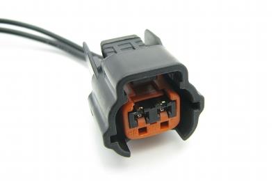 DeatschWerks Nissan side feed fuel injector connectors showing close-up of clips and wiring for secure engine connection.
