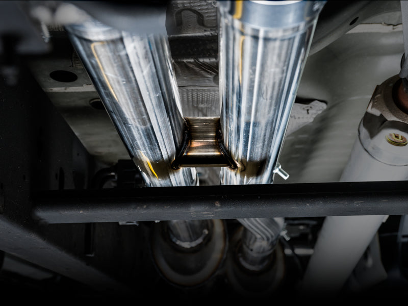AWE Tuning 4th Gen GM 1500 6.2L catback exhaust with split rear exit and quad chrome tips, installed on a pickup truck.