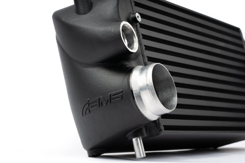 Black AMS Performance intercooler for 2015+ Ford F-150 and Raptor 2.7L/3.5L EcoBoost with AMS logo, showcasing the stock location design.