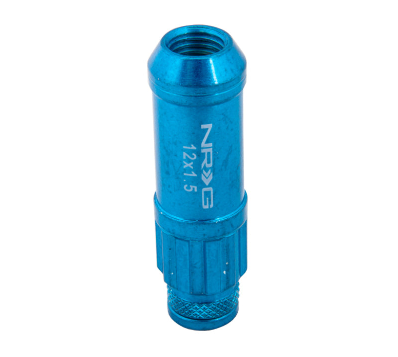 NRG 700 Series M12 x 1.5 steel lug nuts with dust cap cover set, locks, and lock socket in blue, shown on a wheel.
