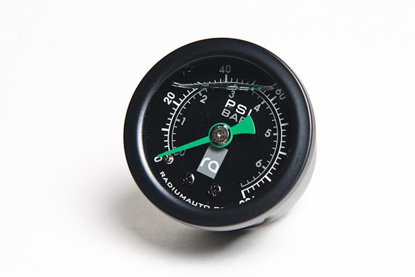 Radium Engineering 0-100 PSI fuel pressure gauge showing dial with black face and white markings for accurate fuel system monitoring.